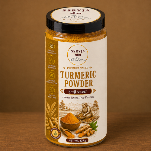 A jar of SSRYJA Turmeric Powder on a wooden surface with a brown background. The jar has a black lid, a cream-colored label with gold and brown text, and illustrations of turmeric roots and a bowl of powder.
