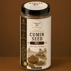 A clear plastic jar of SSRYJA Cumin Seed spice with a black lid and cream-colored label, set against a solid brown background.